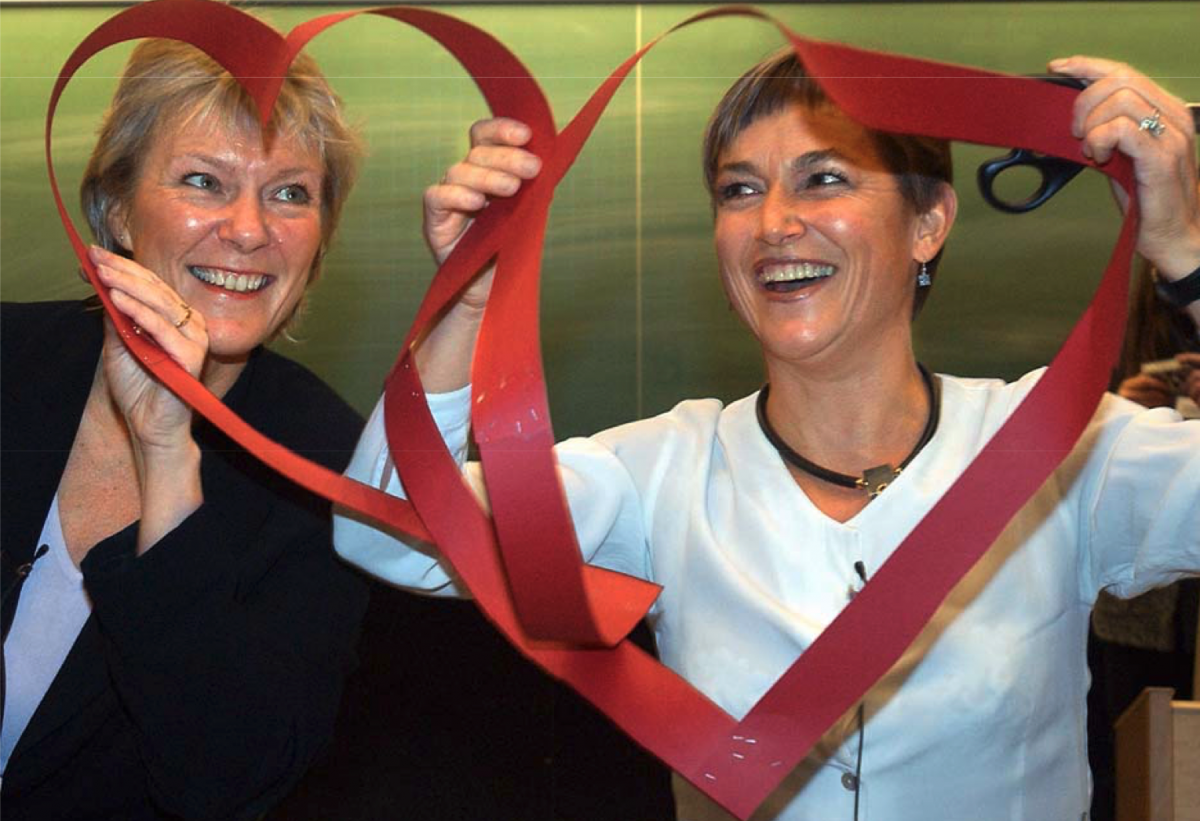 Foto av Kristin Clemet og Ingvill Stedøy som holder i røde bånd som danner to hjerter