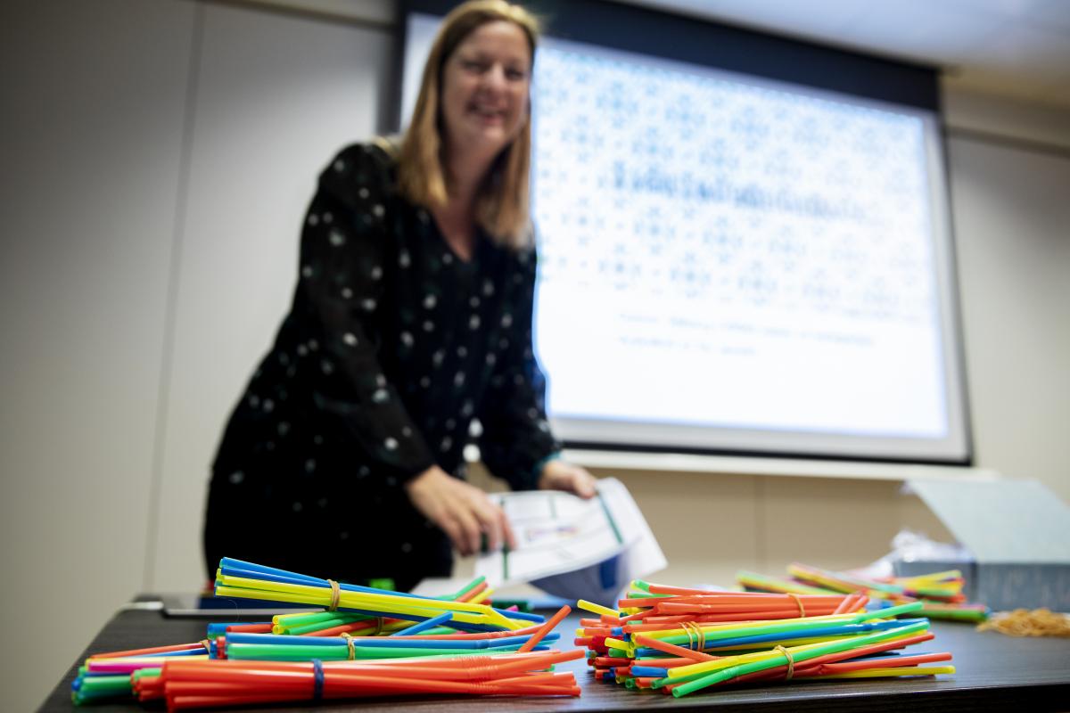Bilde av Else Devold som holder verksted under Novemberkonferansen. Hun har mange fargeblyanter liggende på et bord foran seg.