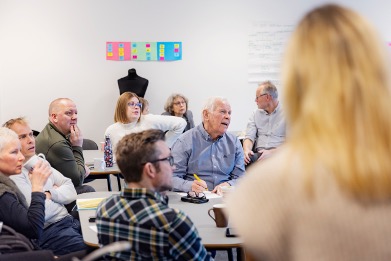 Voksne personer som sitter i et klasserom