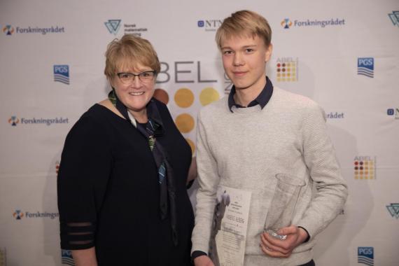 Kunnskapsminister Trine Skei Grande og vinner av Abelkonkurransen, Andreas Alberg. Begge står foran en pressevegg.