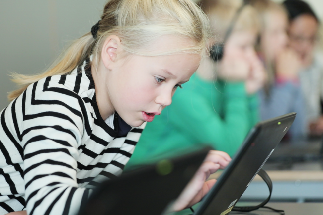 Lita jente som konsentrerer seg mens hun jobber på PC