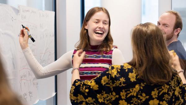 Lærere som står ved vertikal tavle og diskuterer