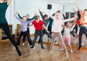 Flere barn og en voksen som danser i en gymsal