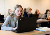 Jente som jobber på en PC