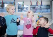 Tre barn som ler og teller på fingre
