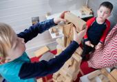 To gutter i barnehagealder som bygger tårn av treklosser