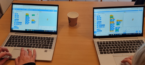 To PC-skjermer hvor lærere arbeider med programmering i Scratch